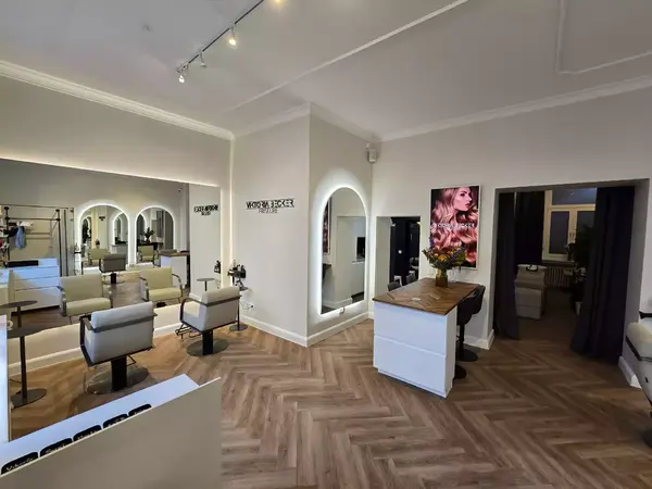 Moderner Friseursalon mit Spiegeln, Stylingstühlen und Empfangstresen