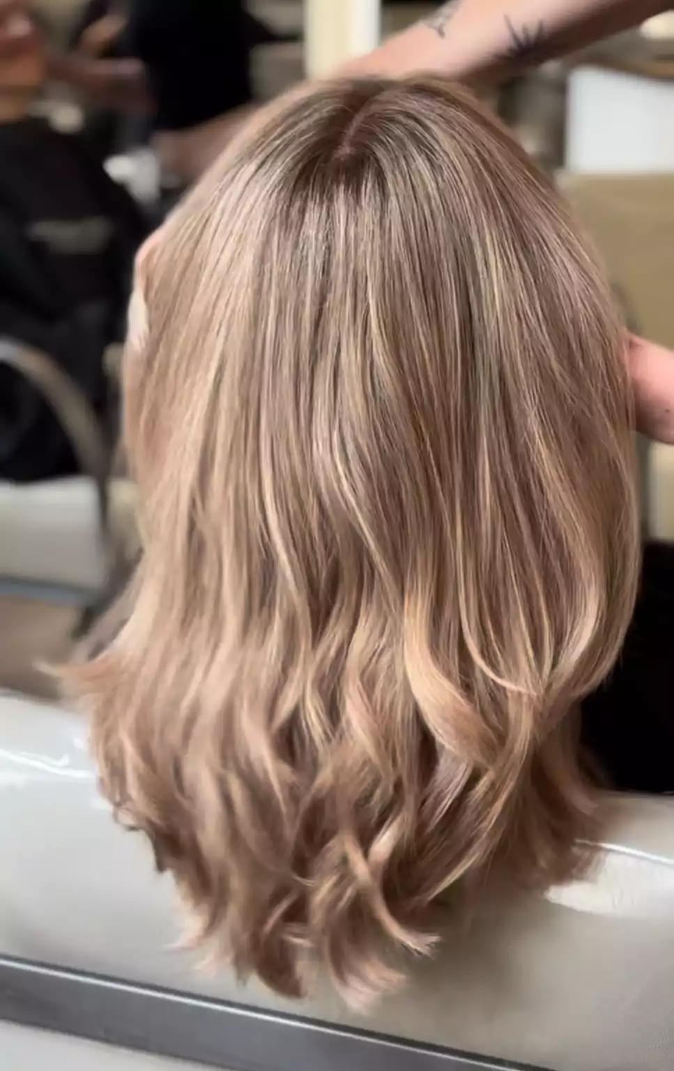 Schulterlanger Bob mit sanften Wellen und Balayage in Beige-Blond im Salon