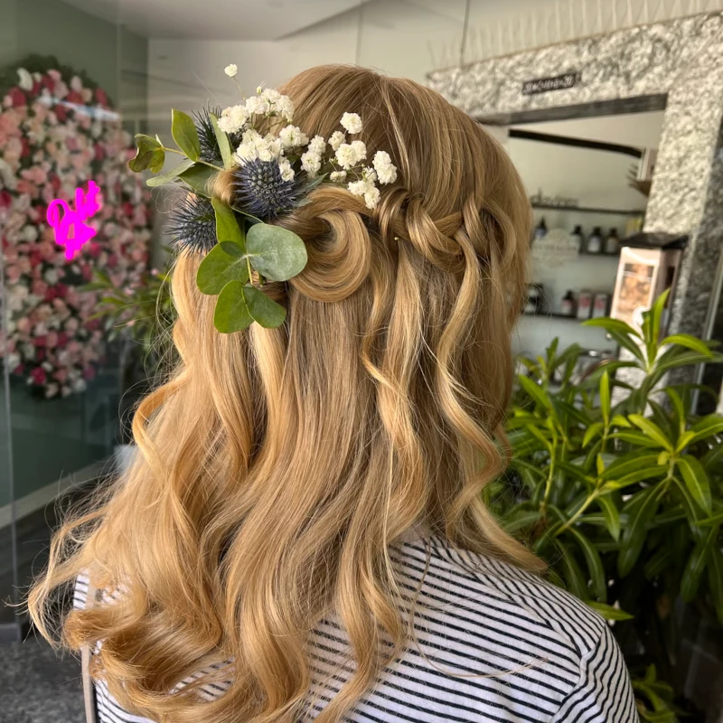 Halboffene Brautfrisur mit Locken und Blumenhaarschmuck im Salon