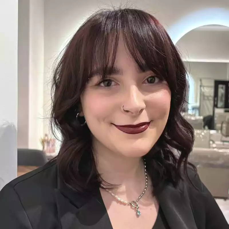 Porträt einer Frau mit dunklen Locken und Pony, Make-up im Friseursalon